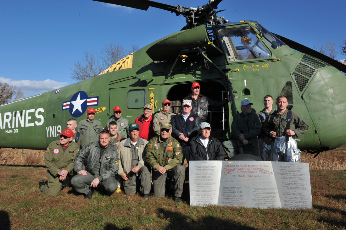 Members of the Marine Squadron 361 Veterans Association posing together for a picture in front of the UH-34D outside the National Museum of the Marine Corps