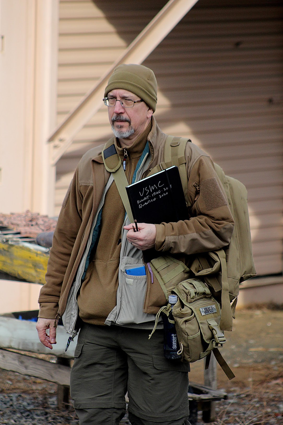 Photo of combat artist Victor Juhasz wearing cold weather gear and holding a sketch book