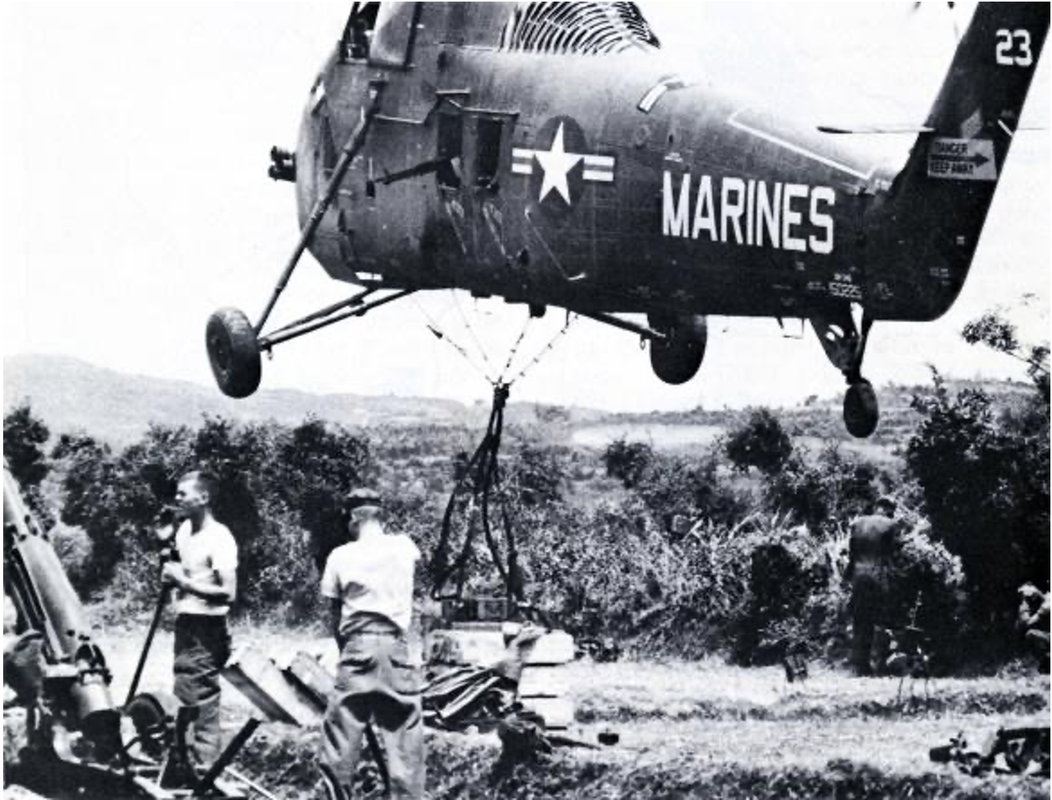A black and white image of a UH-34D helicopter hoisting gear during the Vietnam War.