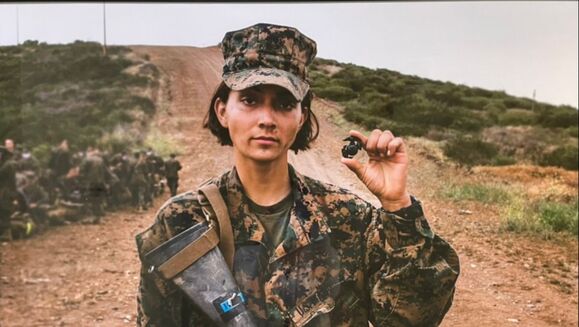 Female Marine holding an eagle, globe and anchor.
